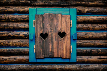 Architecture detail - old wooden window shutters with carved hearts.