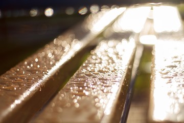 bench after rain with water drops with blurred background close-up and bokeh