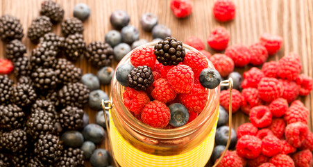 different berries in a basket on a wooden table