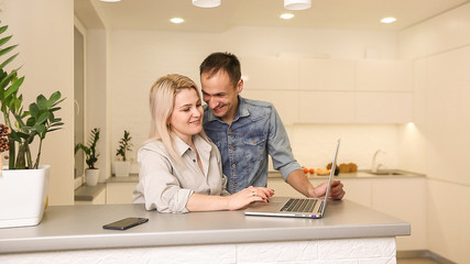 Fototapeta premium Business couple in kitchen woman using laptop