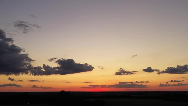 See the beautiful red and orange colors on display in this hyper-lapse video of a Kansas sunset in June. Some clouds rolling across the sky also. Footage captured with drone.
