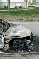 Burnt out car in city street, Riga, Latvia