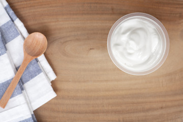 Fototapeta na wymiar Natural homemade plain organic yogurt in cup on wood texture background