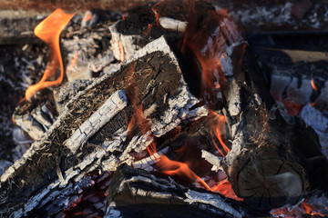 Burning and glowing charcoal with open hot flame and smoke close up