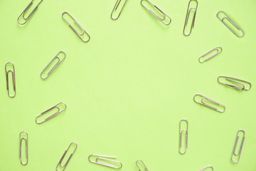High angle view of paper clips on green background