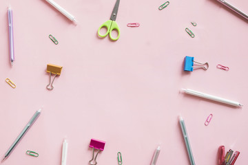 Different type of stationeries on pink background