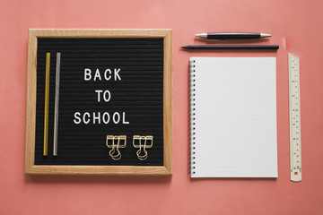 Back to school text on slate with stationeries on colorful background