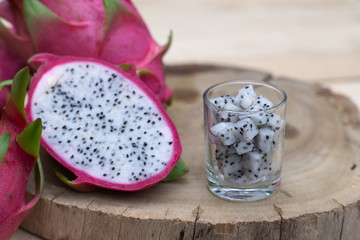 Organic white fresh dragon fruit cut into half on wooden chopping board