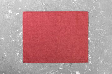 Fototapeta premium red cloth napkin on rustic cement background top view with copy space