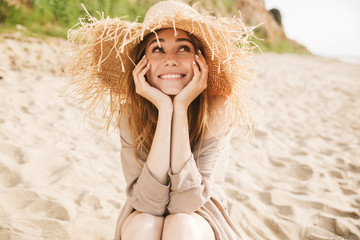 Pleased gorgeous attractive woman posing outdoors at the sea beach.
