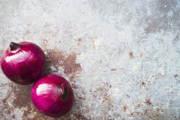 Two red onions on rough background