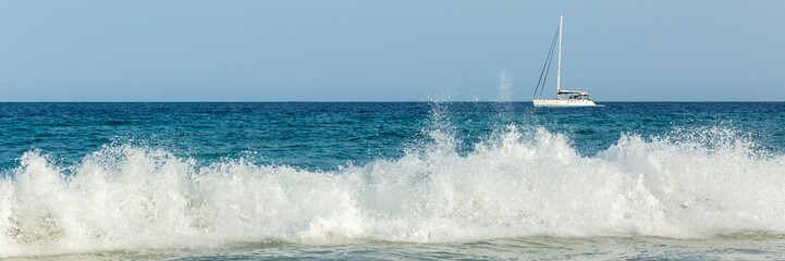 Big waves and white yacht
