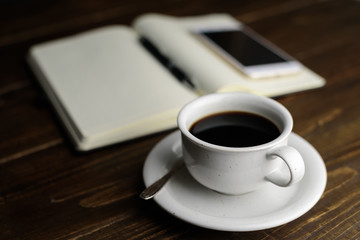Fototapeta na wymiar Black coffee and notebook on desk