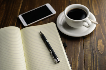Black coffee and notebook on desk