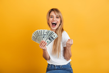 Screaming emotional young blonde woman posing isolated over yellow wall background dressed in white...