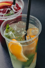 Refreshing drinks for summer, cold sweet and sour lemonade juice with ice cubes in the glasses garnished with sliced fresh lemons