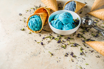 Obraz na płótnie Canvas Trendy Color Changing Ice Cream with blue flowers powder, Butterfly Pea Flower Blossom gelato with ice cream waffle cones
