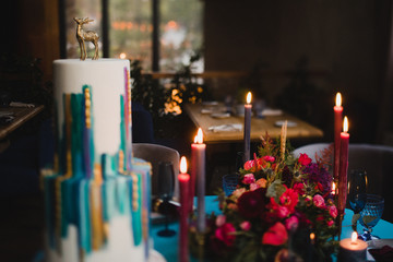 Stylish modern wedding cake. Beautiful dessert decorated with geometric print and golden deer stattuette.