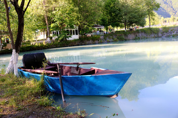 Naklejka na ściany i meble Blue boat with rake on the lake