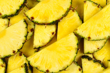 Pineapple juicy yellow slices background. Top view.