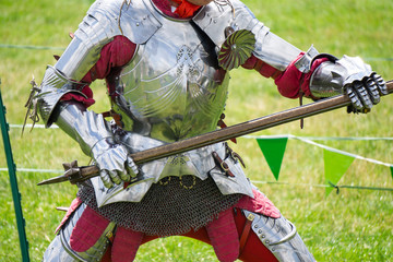 A medieval knight in amrour holding a weapon