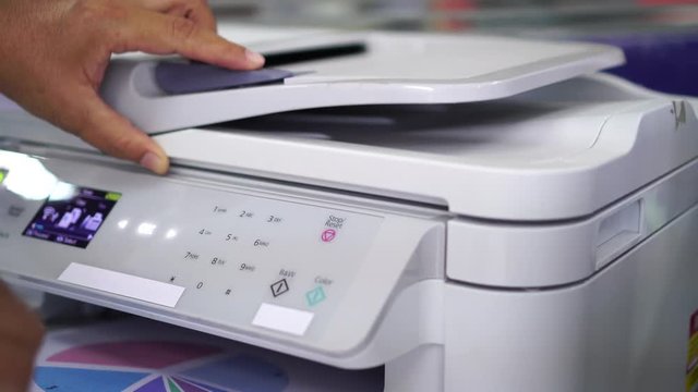 Documents printing concept : Business man hand pressing button machine supplies in control panel laser printer for copy scanner and printing document report graph chart in busy office 