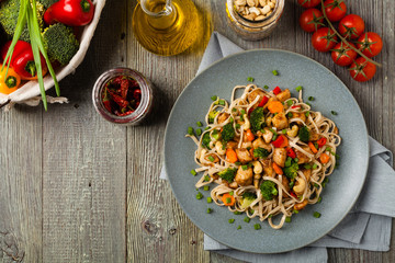 stir-fry pasta with chicken, broccoli and carrots.