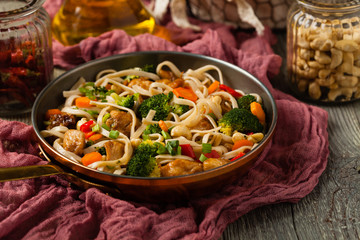 stir-fry pasta with chicken, broccoli and carrots.