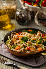 stir-fry pasta with chicken, broccoli and carrots.