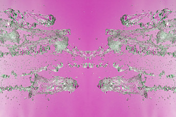 Symmetrical pattern of stopped water droplets with transparent streams on a pink background. Clash,...