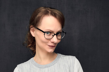 Fototapeta premium Portrait of cute and intrigued young woman with glasses