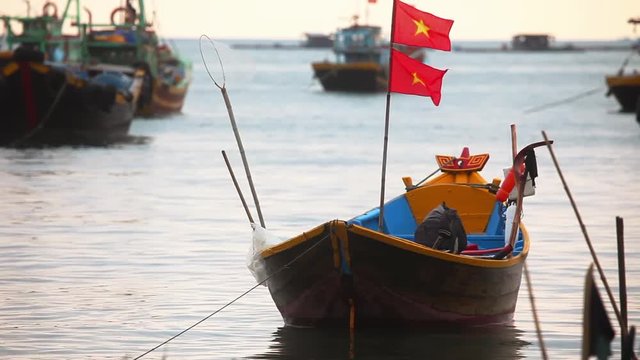 Empty fishing boat in front of the plan, behind the blurred background of the pier