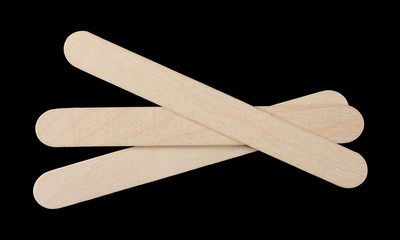 Medical wooden throat inspection spatulas isolated on black background, top view