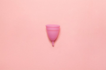 Reusable silicone menstrual cup on a soft pink background. Modern female intimate alternative gynecological hygiene. Eco zero waste concept. Copy space place for text. Flat lay - obrazy, fototapety, plakaty