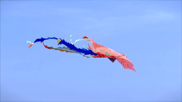 Picture of a Kite Flying in the Air on a Sunny Day Against a Blue Sky and White Clouds and Blue.