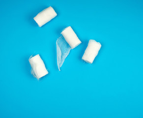 rolled up white sterile medical bandages on a blue background