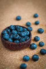 Freshly picked blueberries in woven natural screwpine leaf bowl. Juicy and fresh blueberries with on rustic table. Bilberry on wooden Background. Blueberry antioxidant. Concept for healthy eating.