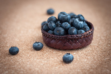 Freshly picked blueberries in woven natural screwpine leaf bowl. Juicy and fresh blueberries with on rustic table. Bilberry on wooden Background. Blueberry antioxidant. Concept for healthy eating.