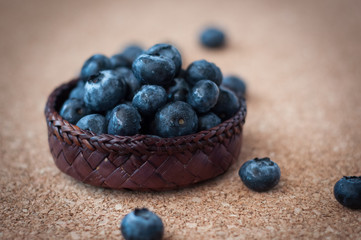 Freshly picked blueberries in woven natural screwpine leaf bowl. Juicy and fresh blueberries with on rustic table. Bilberry on wooden Background. Blueberry antioxidant. Concept for healthy eating.