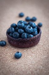 Freshly picked blueberries in woven natural screwpine leaf bowl. Juicy and fresh blueberries with on rustic table. Bilberry on wooden Background. Blueberry antioxidant. Concept for healthy eating.
