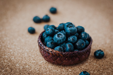Freshly picked blueberries in woven natural screwpine leaf bowl. Juicy and fresh blueberries with on rustic table. Bilberry on wooden Background. Blueberry antioxidant. Concept for healthy eating.