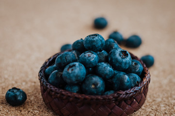 Freshly picked blueberries in woven natural screwpine leaf bowl. Juicy and fresh blueberries with on rustic table. Bilberry on wooden Background. Blueberry antioxidant. Concept for healthy eating.