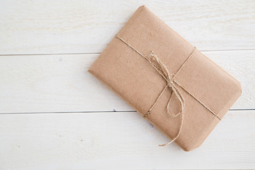 parcel,gift Packed in eco-friendly paper on light wooden background. the view from the top