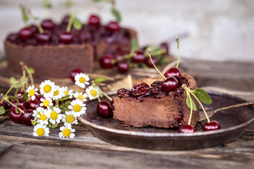 chocolate cheesecake with fresh cherry on wooden background