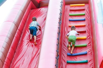 having fun on the slide in the fun park in bouncy castle competing