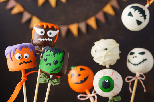 Halloween cake pops and marshmallow with funny monster faces.