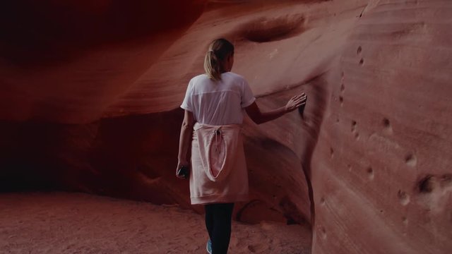 TRACKING Caucasian female exploring Antelope Canyon, Arizona. 4K UHD RAW edited footage