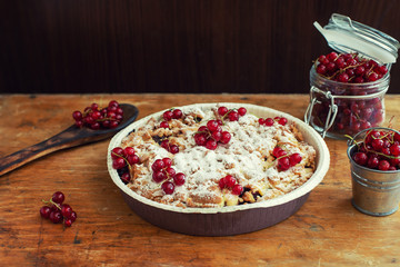 tasty homemade pie and fresh red currants in jar on old wooden table
