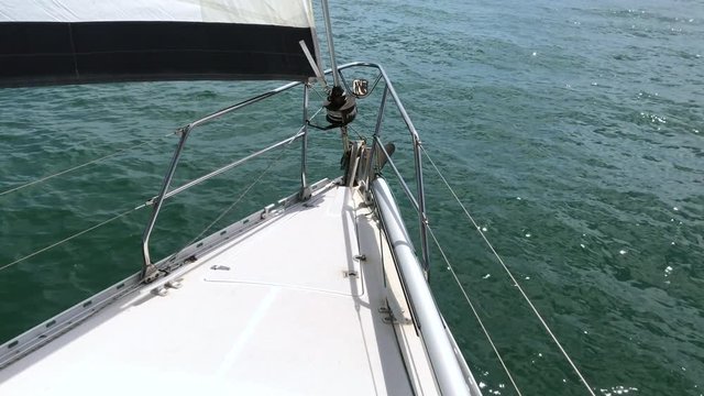 A yacht sailing in light winds, on starboard tack with main and genoa hoisted, on a sunny day in calm coastal waters. A relaxing calming soothing film