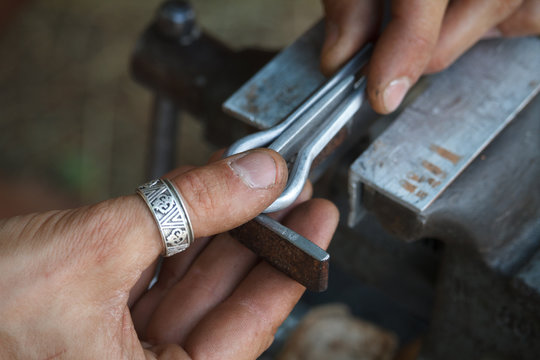 Close-up of a man's hand makes a jaw harps, khomuses, folk musical instruments, selective focus